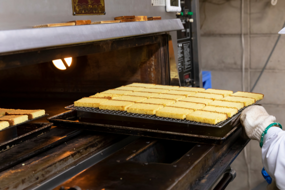 オーブンに並べられ焼かれているカステラのスライス